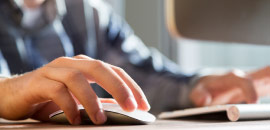 person's hands maneuvering computer mouse